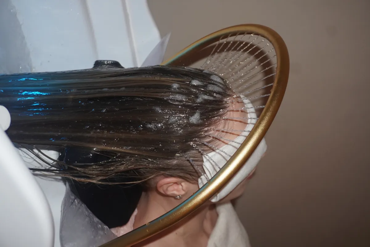Rinçage du cuir chevelu sous l’arceau doré du head spa, salon Atelier Kora Marseille